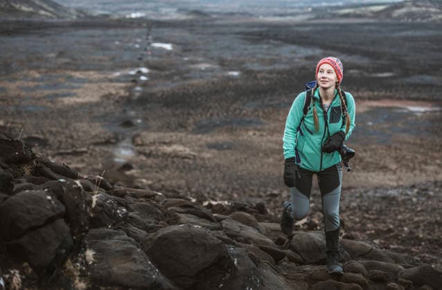 Young woman with camera hikes in lava field, Helgafell, Iceland Reykjavík, Reykjavíkurborg, Iceland CR_SSNF260305D-1943191-01 ,model released, Symbolfoto