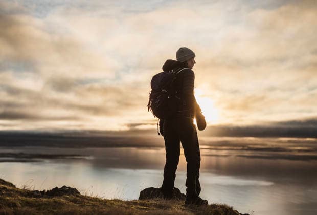 Female hiker looking at view at sunset while hiking in winter, Iceland Akranes, Akraneskaupstaður, Iceland CR_SSNF260305D-1943199-01 ,model released, Symbolfoto
