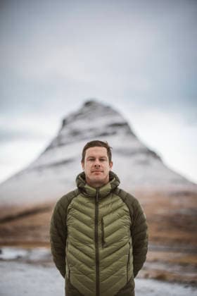 Portrait of a man in jacket in front of snowy mountain, Iceland Grundarfjörður, Grundarfjarðarbær, Iceland CR_SSNF260305D-1943206-01 ,model released, Symbolfoto