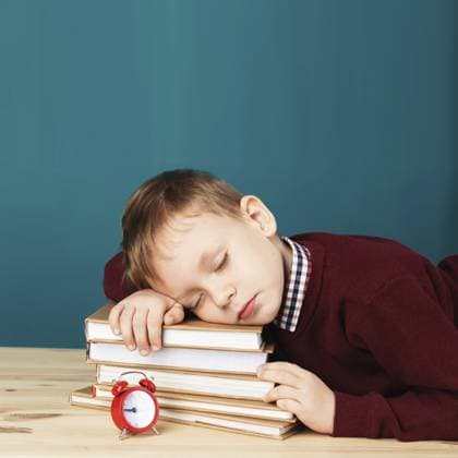 Müder Schuljunge schläft auf Büchern. Kleiner Student schläft in Lehrbüchern. Ein Kind in Schuluniform liegt auf dem Tisch mit einem großen Stapel Bücher vor einer blauen Wand. Augen geschlossen. Schulkonzept. Zurück zur Schule Tired school boy asleep on books. little student sleeping on textbooks. Child in school uniform lies on the table with big pile of books against blue wall. Eyes closed. School concept. Back to school Copyright: imageBROKER NataliiaxZhekova ibxiqx16148534.jpg ,model released, Symbolfoto ,property released