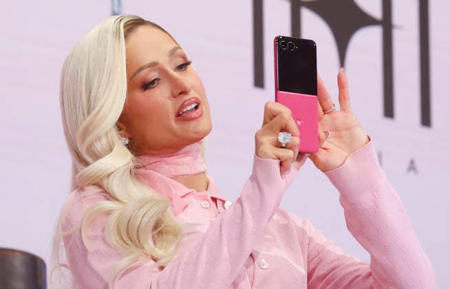Founder & CEO 11:11 Media Paris Hilton holds a pink cell phone after ringing the closing bell to celebrate International Women s Day at the New York Stock Exchange on Wall Street on Monday, March 9, 2026 in New York City. The S&P 500 made a comeback from earlier losses on Monday after President Donald Trump said the war against Iran could be reaching its end.  NYP2026030309172 JOHNxANGELILLO