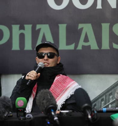 Kneecap s member hold a press conference in Belfast BELFAST, NORTHERN IRELAND - MARCH 11: Kneecap s Mo Chara, Muhllai Bap, DJ Provai hold a press conference at Conway Mill in Belfast, Northern Ireland on March 11, 2026. The UK government lost its appeal over a judge s decision to dismiss terror charges against Liam Og O hAnnaidh, known as Mo Chara related to allegedly displaying a Hezbollah flag at a concert in London in November 2024. The High Court delivered its judgment in an appeal brought by the Director of Public Prosecutions (DPP) challenging the magistrates’ court ruling that dismissed the case against the band member. Conor Mccaughley Anadolu Belfast Ireland. Editorial use only. Please get in touch for any other usage.  Copyright: x2026xAnadoluxConorxMccaughleyx