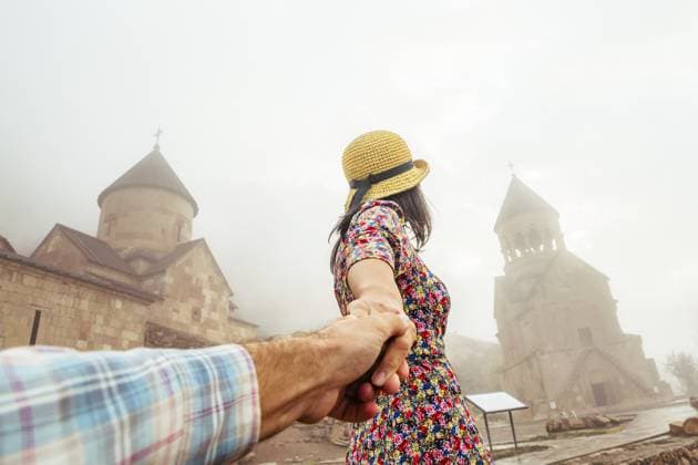 Die Millennial Bloggershow Follow me aus nächster Nähe zu den Touristenattraktionen Armeniens. Glückliche Reisende tragen ein rotes Sommerkleid am Eingang des berühmten Noravank Klosters Close up millennial blogger show Follow me hold hand to the tourist attractions of Armenia. Happy woman traveler wear red summer dress at the entrance to famous Noravank monastery Copyright: imageBROKER EvaldasxMikoliunas ibxemi16914732.jpg ,model released, Symbolfoto ,property released
