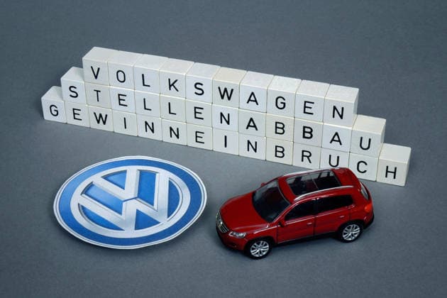 VW-Logo mit einem Matchboxauto Tiguan und Buchstabenwürfel mit Volkswagen, Stellenabbau und Gewinneinbruch Fotomontage: VW-Logo mit einem Matchboxauto Tiguan und Buchstabenwürfel mit Volkswagen, Stellenabbau und Gewinneinbruch, 11.03.2026, Borkwalde, Brandenburg, Neben einem VW-Logo befinden sich ein Matchboxauto Tiguan und Buchstabenwürfel mit den Schriftzügen Volkswagen, Stellenabbau und Gewinneinbruch. *** VW logo with a matchbox car Tiguan and letter cube with Volkswagen, job cuts and slump in profits Photomontage VW logo with a matchbox car Tiguan and letter cube with Volkswagen, job cuts and slump in profits, 11 03 2026, Borkwalde, Brandenburg, Next to a VW logo are a matchbox car Tiguan and letter cubes with the lettering Volkswa