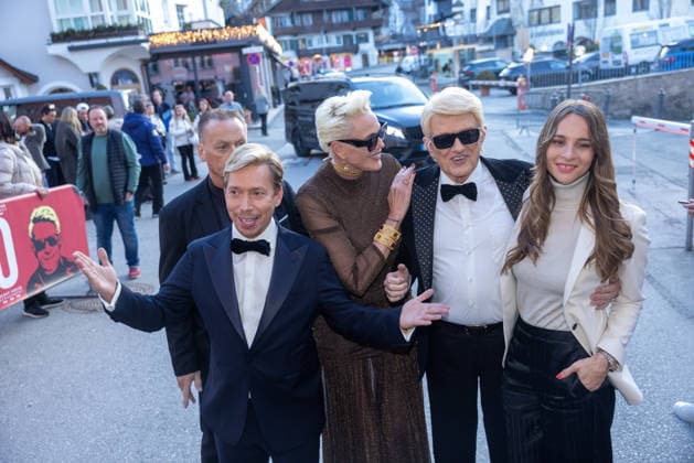 Datum: 13.03.26 Ort: Kitzbühel Im Bild: Helmut Werner, Brigitte Nielsen, Heino, Nicole Werner Er ist Kult blonde Haare, schwarze Sonnenbrille und eine unverwechselbare Jahrhundertstimme: Heino (87) blickt auf eine fast 70-jährige Karriere zurück. Doch nur wenige kennen die Geschichte hinter seiner berühmten dunklen Brille. Der Sänger, der bürgerlich Heinz Georg Kramm heißt, hat in seinem Leben über 55 Millionen Tonträger verkauft. Ob Schlager, Pop, Heavy Metal, Ballermann, Rap oder Klassik kaum ein Genre blieb ihm fremd. Bis heute steht der Kultstar auf der Bühne: Er tritt bei großen Festivals wie dem Parookaville vor Zehntausenden Fans genauso selbstverständlich auf wie bei klassischen Kirchenkonzerten, etwa in der xchristian esslerx