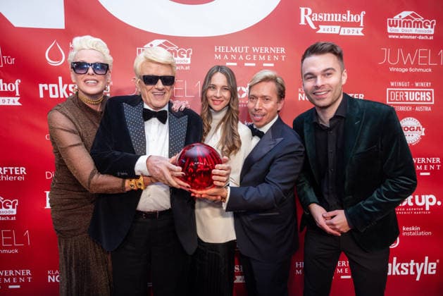 Datum: 13.03.26 Ort: Kitzbühel Im Bild: Brigitte Nielsen, Heino, Nicole Werner, Helmut Werner, Benedict Bartsch Er ist Kult blonde Haare, schwarze Sonnenbrille und eine unverwechselbare Jahrhundertstimme: Heino (87) blickt auf eine fast 70-jährige Karriere zurück. Doch nur wenige kennen die Geschichte hinter seiner berühmten dunklen Brille. Der Sänger, der bürgerlich Heinz Georg Kramm heißt, hat in seinem Leben über 55 Millionen Tonträger verkauft. Ob Schlager, Pop, Heavy Metal, Ballermann, Rap oder Klassik kaum ein Genre blieb ihm fremd. Bis heute steht der Kultstar auf der Bühne: Er tritt bei großen Festivals wie dem Parookaville vor Zehntausenden Fans genauso selbstverständlich auf wie bei klassischen Kirchenkonz xchristian esslerx