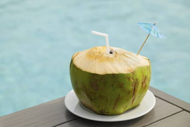 Frisches Kokosnussgetränk auf dem Tisch neben dem Pool Fresh coconut drink on the table beside the swimming pool Copyright: imageBROKER blackday ibxiqx16979489.jpg ,model released, Symbolfoto ,property released