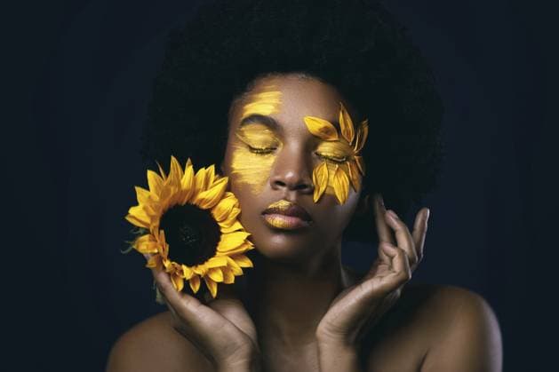 Schöne Afrikanerin mit Sonnenblume und kreativem Make up im Gesicht Lovely African woman with a sunflower and creative makeup on her face Copyright: imageBROKER blackday ibxiqx16981704.jpg ,model released, Symbolfoto ,property released