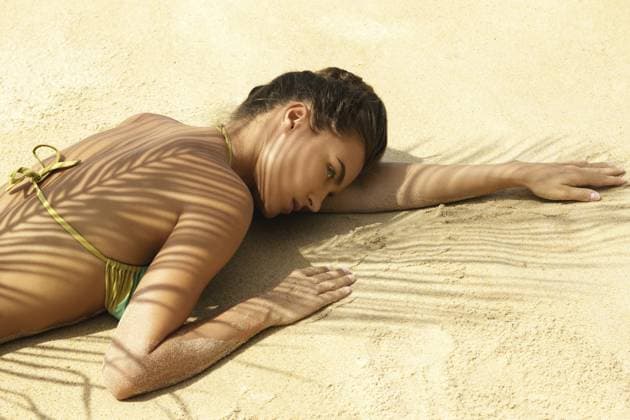 Heißer Sommertag. Schöne Frau liegt am Strand unter Palmblättern Hot summer day. Beautiful woman is lying on the beach under palm leaf Copyright: imageBROKER blackday ibxiqx16982543.jpg ,model released, Symbolfoto ,property released