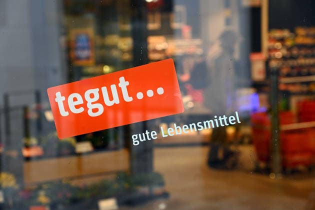 Der Schweizer Konzern Migros zieht sich aus Deutschland zurueck und verkauft die Supermarktkette Tegut. Rund 200 der etwa 340 Filialen will Edeka uebernehmen. Tegut ist ein deutsches Handelsunternehmen und Vollsortimenter im Lebensmitteleinzelhandel mit Hauptsitz in Fulda. Tegut betreibt ueber 300 Filialen mit rund 8400 Mitarbeitern in Hessen, Bayern, Niedersachsen, Rheinland-Pfalz, Thueringen und Baden-Wuerttemberg. Supermarkt,Filiale,Lebensmittel,Eingang, Firmenlogo,