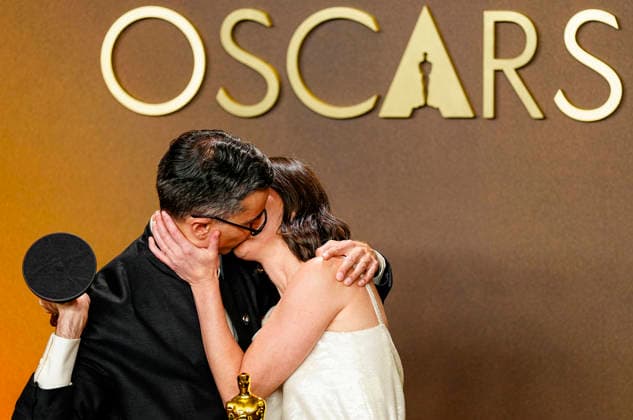 Natalie Musteata and Alexander Singh exchange a kiss during celebrations in the press photo room after winning the Best Live Action Short Film Oscar for Two People Exchanging Saliva during the 98th annual Academy Awards in the Hollywood section of Los Angeles on Sunday, March 15, 2026. Conan O Brien is hosting the Oscars for the second consecutive year.  LAP20260315351 BONNIExCASH