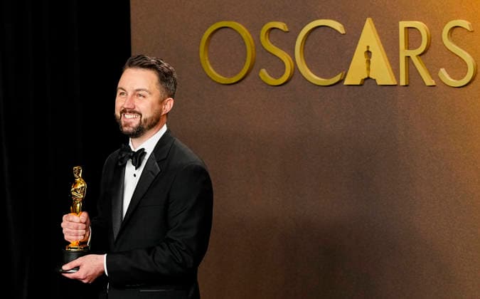 Andy Jurgensen celebrates in the press photo room after winning the Best Film Editing Oscar for One Battle After Another during the 98th annual Academy Awards in the Hollywood section of Los Angeles on Sunday, March 15, 2026.  LAP20260315385 BONNIExCASH