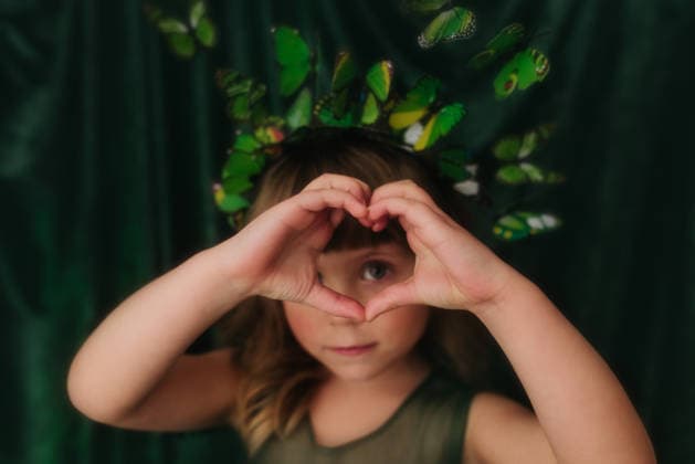 Young girl makes shape of heart with hands in front of green backdrop Sioux Falls, South Dakota, United States CR_ASWE260315-1980231-01 ,model released, Symbolfoto