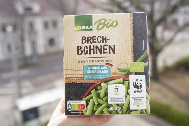 Verpackung von Edeka Bio Brechbohnen mit WWF-Logo und Straßenansicht im verschwommenen Hintergrund, tiefgekühlt, geforen, erntefrisch tiefgefroren, eingeforen, lange haltbar, haltbarmachung, gesund, Tiefkühlprodukt, Produkt, biologisch Packaging of Edeka organic beans with WWF logo and street view in a blurred background, frozen, freshly harvested frozen, frozen, sealed, long shelf life, shelf life, healthy, frozen product, organic Copyright: imageBROKER brandxnews iblbee17041391.jpg