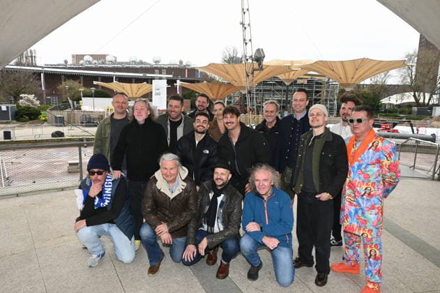 Gruppenbild der Bands und Veranstalter der autretenden Künstler posieren bei der Programm PK vor der Baustelle des Kölner Tanzbrunnen der nach umfangreicher Sanierung pünktlich zu Saisonstart am 09.05.2026 fertig sein soll