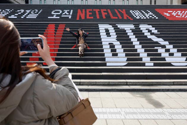 Fans of the K-pop group BTS pose for commemorative photos decorated with promotional material for the upcoming BTS concert in Seoul, South Korea, March 18, 2026. BTS is scheduled to perform their comeback concert, BTS THE COMEBACK LIVE: ARIRANG, at Gwanghwamun Square on March 21, 2026. Matrix Images Jung Ui-Chel 