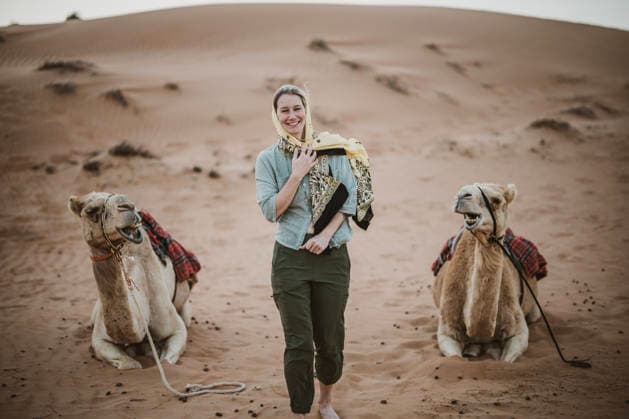 Woman in hijab laughs while walking between two camels Bidiyah, Ash Sharqiyah North Governorate, Oman CR_SSNF260316B-1977666-01 ,model released, Symbolfoto