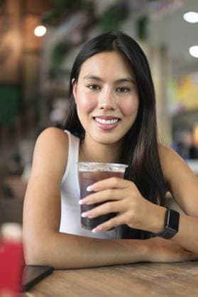IMAGO Creative, Food, Trend, Iced Coffee Junge schöne asiatische Frau sitzt und trinkt Eiskaffee im Restaurant Young beautiful Asian woman sitting and drinking iced coffee at restaurant Copyright: imageBROKER TonixRantala ibxiqx16930133.jpg ,model released, Symbolfoto ,property released
