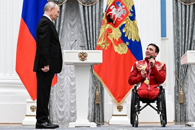 Russia Putin Paralympic Athletes 9126956 19.03.2026 Russian President Vladimir Putin listens as Paralympic champion in the men™s 10km and 20km interval start sitting para cross-country skiing Ivan Golubkov, awarded the Order of Friendship, speaks during a state awards ceremony for the Russian medalists of the Milano Cortina 2026 Winter Paralympic Games at the Kremlin in Moscow, Russia. Sergey Bobylev Sputnik Moscow Russia  Copyright: xSergeyxBobylevx