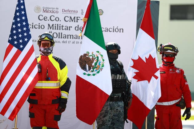 Military exercise under the Kukulcan security plan for the 2026 FIFA World Cup in Mexico ZUMPANGO, MEXICO - MARCH 19: Members of the Mexican Army and rescue teams hold flags of the United States, Mexico and Canada during the Ollamani military exercise, at the Santa Lucia Air Force base, in Zumpango, Mexico on March 19, 2026. According to Mexican authorities, the exercise is part of interagency security coordination under the Kukulcan security plan for the 2026 FIFA World Cup, involving technical groups set up by a high-level committee on disarmament, terrorism and international security. Daniel Cardenas Anadolu Zumpango Mexico. Editorial use only. Please get in touch for any other usage.  Copyright: x2026xAnadoluxDanielxCardenasx