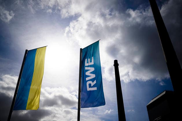 Feature, Fahne der RWE AG auf dem RWE Campus, Ukrainer Flagge, UKR, Logo, Himmel, Sonne, Schriftzug, dahinter das Heizwerk Essen-Innenstadt. Bilanzpressekonferenz der RWE AG, am 12.03.2026 in Essen Deutschland. @ RWE Campus *** Feature, flag of RWE AG on the RWE Campus, Ukrainian flag, UKR, logo, sky, sun, lettering, behind it the heating plant Essen city center balance sheet press conference of RWE AG, on 12 03 2026 in Essen Germany @ RWE Campus