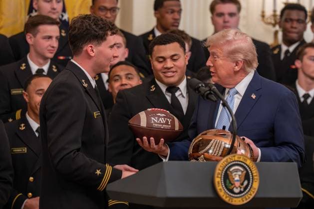 March 20, 2026, Washington, District Of Columbia, USA: President DONALD TRUMP is presented with gifts by Navy Midshipmen players BLAKE HORVATH and LANDON ROBINSON during an event in the East Room of the White House. Washington USA - ZUMAs365 20260320_znp_s365_027 Copyright: xJoeyxSussmanx