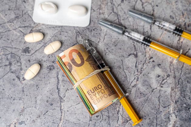Bavaria, Germany March 20, 2026: Medications, syringes, and euro banknotes used as cash symbolize rising drug prices and healthcare costs. The image illustrates the connection between medical treatment, financial burden, and risks such as drug abuse and addiction. *** Medikamente, Spritzen und Euro-Banknoten als Bargeld symbolisieren steigende Medikamentenpreise und Gesundheitskosten. Das Bild zeigt den Zusammenhang zwischen Behandlung, finanzieller Belastung sowie Risiken wie Drogenmissbrauch und Abhängigkeit.