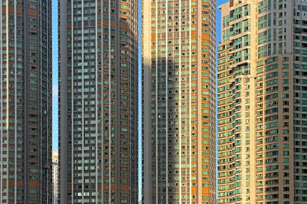 Creative Highlights World Reihen identischer Wohnhäuser mit vielen Fenstern unter strahlender Sonne und Schatten A dense urban landscape featuring numerous hig rise residential towers with repetitive window patterns bathed in warm sunlights (License=RF) Copyright: xZoonar.com cougarsanx 24776908