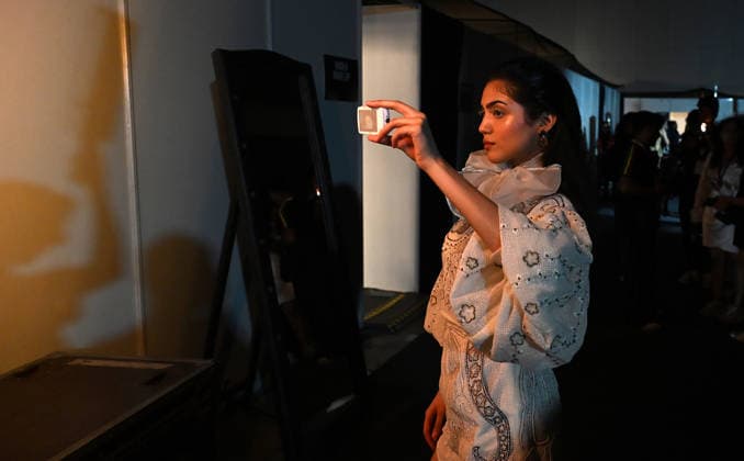 March 21, 2026, Mumbai, Maharashtra, India: A model is seen using a small camera to take photo in-between the show at the Lakme Fashion Week (LFW) in Mumbai. Mumbai India - ZUMAs197 20260321_aaa_s197_106 Copyright: xAshishxVaishnavx