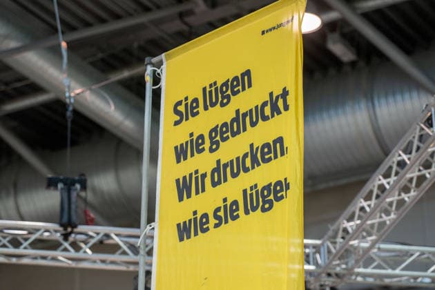Leipzig - Volle Hallen zum letzten Messetag: Abschluss auf der Leipziger Buchmesse 22.03.2026¨Leipzig, Messe-Allee (Leipziger Messe) im Foto: Slogan Sie lügen wir gedruckt. Wir drucken wie sie lügen. der Zeitung junge Welt¨¨Am Sonntag hat die Leipziger Buchmesse noch einmal zahlreiche Besucher auf das Messegelände gelockt und einen lebendigen Abschluss des diesjährigen Events geboten. Besonders Familien, Literaturfans und Cosplay-Begeisterte nutzten den letzten Messetag, um durch die Hallen zu schlendern, Neuerscheinungen zu entdecken und Autorinnen und Autoren hautnah zu erleben. Neben gut besuchten Lesungen und Signierstunden stand vor allem der Austausch im Mittelpunkt: Gespräche über aktuelle gesellschaftliche T Copyright: xEHLxMedia Erik-HolmxLanghofx 20260322_buchmesse-leipzig-sonntag_31