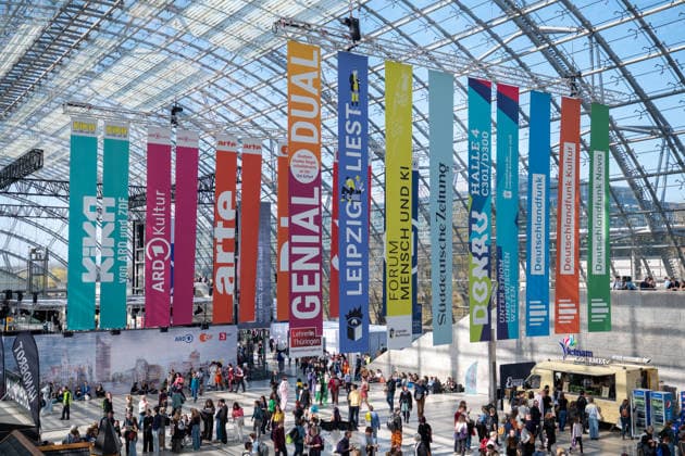 Leipzig - Volle Hallen zum letzten Messetag: Abschluss auf der Leipziger Buchmesse 22.03.2026¨Leipzig, Messe-Allee (Leipziger Messe) im Foto: Werbebanner in der Glashalle zur Buchmesse ¨Am Sonntag hat die Leipziger Buchmesse noch einmal zahlreiche Besucher auf das Messegelände gelockt und einen lebendigen Abschluss des diesjährigen Events geboten. Besonders Familien, Literaturfans und Cosplay-Begeisterte nutzten den letzten Messetag, um durch die Hallen zu schlendern, Neuerscheinungen zu entdecken und Autorinnen und Autoren hautnah zu erleben. Neben gut besuchten Lesungen und Signierstunden stand vor allem der Austausch im Mittelpunkt: Gespräche über aktuelle gesellschaftliche Themen, neue Buchtrends und die Zukunft der Branche prÃ Copyright: xEHLxMedia Erik-HolmxLanghofx 20260322_buchmesse-leipzig-sonntag_59