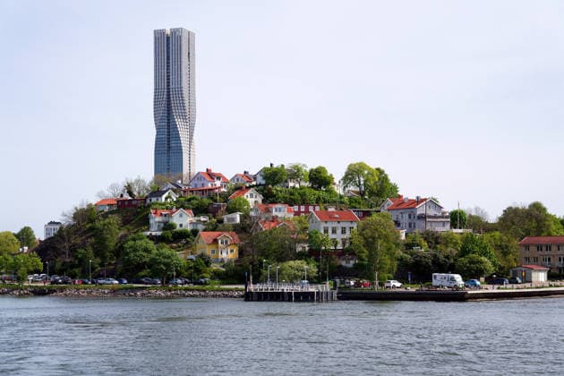 Kolonie kleiner historischer Holzhäuser auf dem Berg Slottsberget mit dem höchsten skandinavischen Gebäude, dem Karlatornet-Hochhaus in Lindholmen, Göteborg, Schweden Colony of small wooden historic houses on the Slottsberget mountain with the tallest Scandinavian building Karlatornet skycraper in Lindholmen, Gothenburg, Sweden (License=RF) Copyright: xZoonar.com JosefxKube?x 24180033