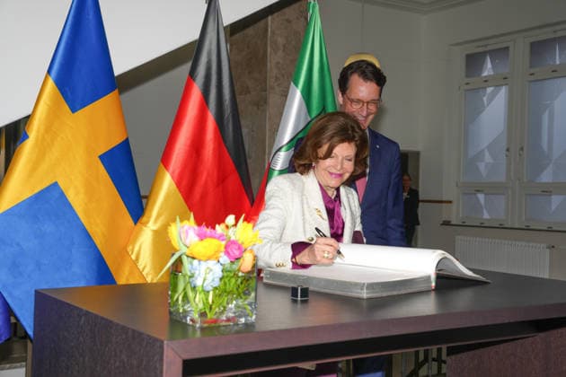 NRW Ministerpraesident Wuest begruesst Koenigin SIlvia von Schweden Koenigin Silvia von Schweden traegt sich in das goldene Buch der Staatskanzlei daneben NRW Ministerpraesident Hendrik Wuest Duesseldorf, 23.03.2026 Duesseldorf NRW Deutschland