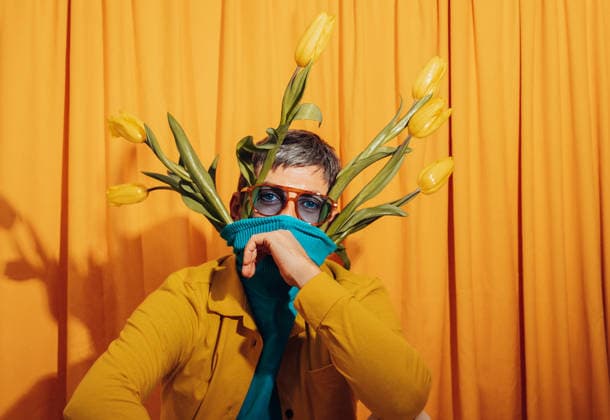Whimsical man with tulips and blue sweater in front of orange curtain model released, Symbolfoto, AAF00472