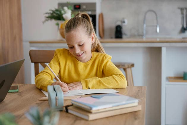 Child smiling while writing homework at home in modern kitchen model released, Symbolfoto property released, FLMZF03090
