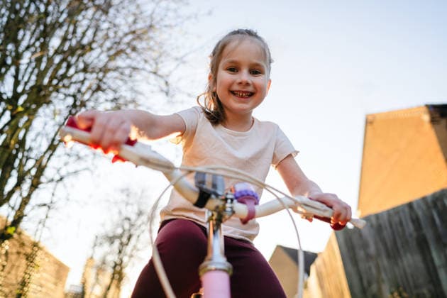 Smiling child riding bicycle outdoors enjoying family time in spring model released, Symbolfoto, IGEF00804