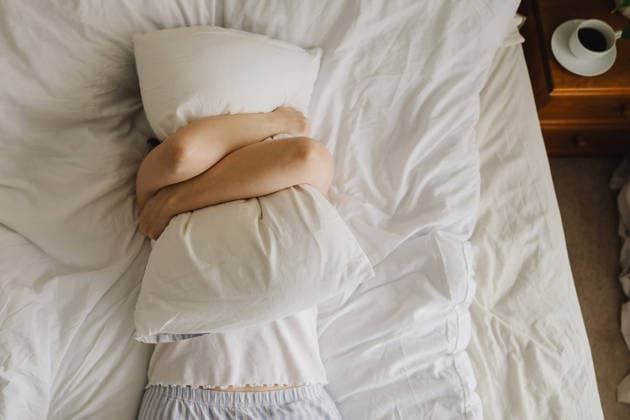 Fatigued woman hugging pillow in bed during a stressful morning model released, Symbolfoto property released, IGEF00811