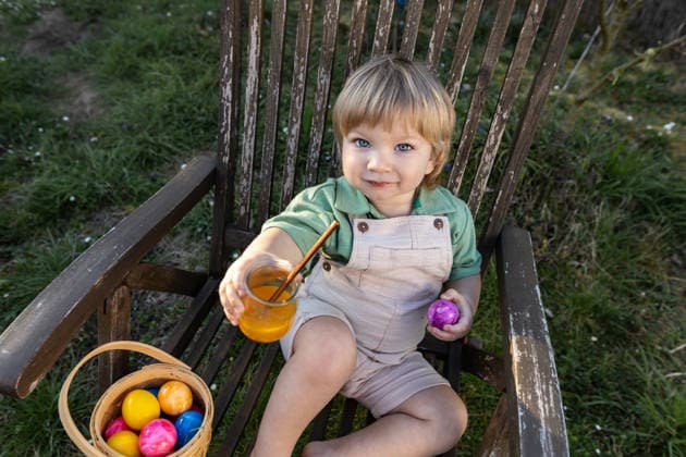 Child enjoying Easter egg hunt with basket of painted eggs outdoors model released, Symbolfoto, Mainy RLP Germany ALPF00108