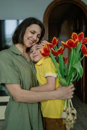 Woman hugging child with tulip bouquet celebrating Women s Day model released, Symbolfoto property released, ANAF05699