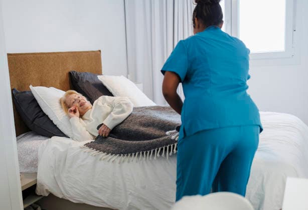 Nurse assisting elderly patient with therapy and care in bedroom model released, Symbolfoto property released, JCCMF14639