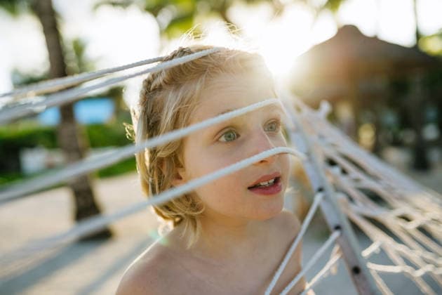 Boy under hammock during tropical family vacation. Boy under hammock during tropical family vacation. Summer holiday. model released