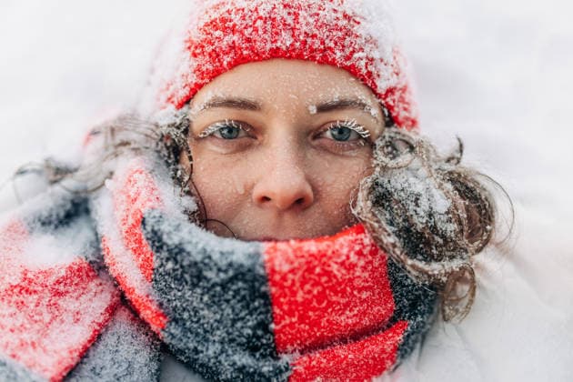 Face close-up of woman in winter with red knit hat and frosty eyelashes outdoors model released, Symbolfoto, NASF00155