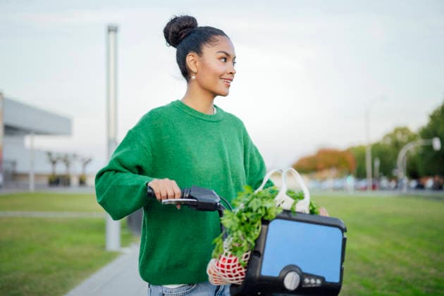 Woman riding electric bike with groceries in urban setting outdoors model released, Symbolfoto, PGF02361