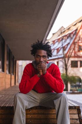 Man in red sweater pondering outdoors in old town urban setting model released, Symbolfoto, PLF00020
