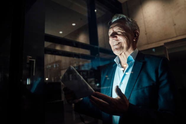 Businessman using tablet during evening team meeting in modern office model released, Symbolfoto property released, RAYF01609