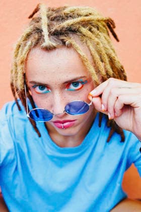 Young woman with dreadlocks and sunglasses posing joyfully model released, Symbolfoto, SVCF00593