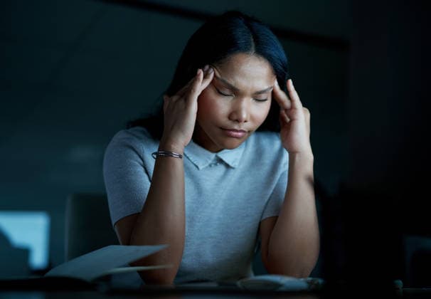 Headache, fatigue and businesswoman in office at night with exhaustion, stress or frustration. Migraine, tired and female creative editor with burnout for publishing project with deadline at startup model released property released Copyright: xwww.peopleimages.comx