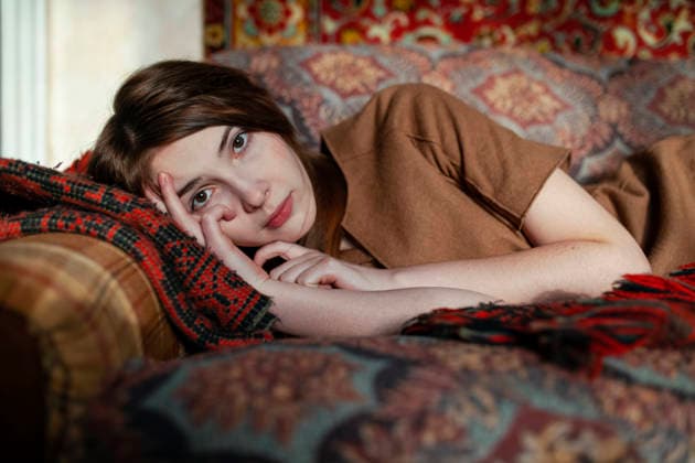 Young woman lying on sofa with vintage bedding in old house model released, Symbolfoto property released, VCF01382