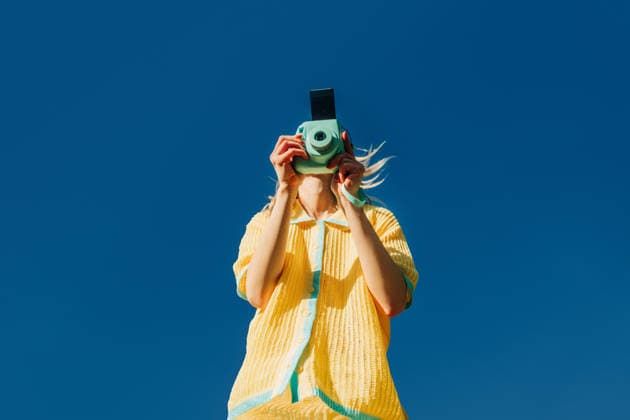 Fashionable woman taking photo with retro camera outdoors in spring model released, Symbolfoto, VSNF04697