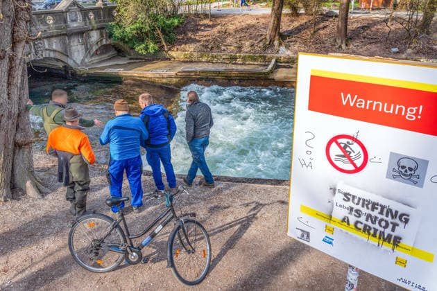 Experten des städtischen Wasserwirtschaftsamts begutachten die Eisbachwelle, der Pegel des Eisbachs ist heute morgen zeitweilig um einen Meter abgesenkt worden, aktuell weiter Surfverbot, München, 24. März 2026 Deutschland, München, 24. März 2026, Experten des städtischen Wasserwirtschaftsamts begutachten die Eisbachwelle, der Pegel des Eisbachs ist heute morgen zwischen 8 und 9 Uhr zeitweilig um einen Meter abgesenkt worden, hat nichts mit der Reparatur der Eisbachwelle zu tun, sondern der Pegel ist wegen Bauarbeiten weiter unten am Eisbach gesenkt worden, aktuell weiter Surfverbot, Protest der Surfer: Surfing is not a crime, derzeit gibt es weiterhin nur unsurfbares Weißwasser, Verbot sorgt für Ärger in der Münchner Surfcommun